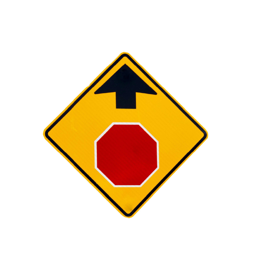 Yellow diamond traffic sign showing a red octagon with a black arrow above it to highlight an upcoming stop sign.