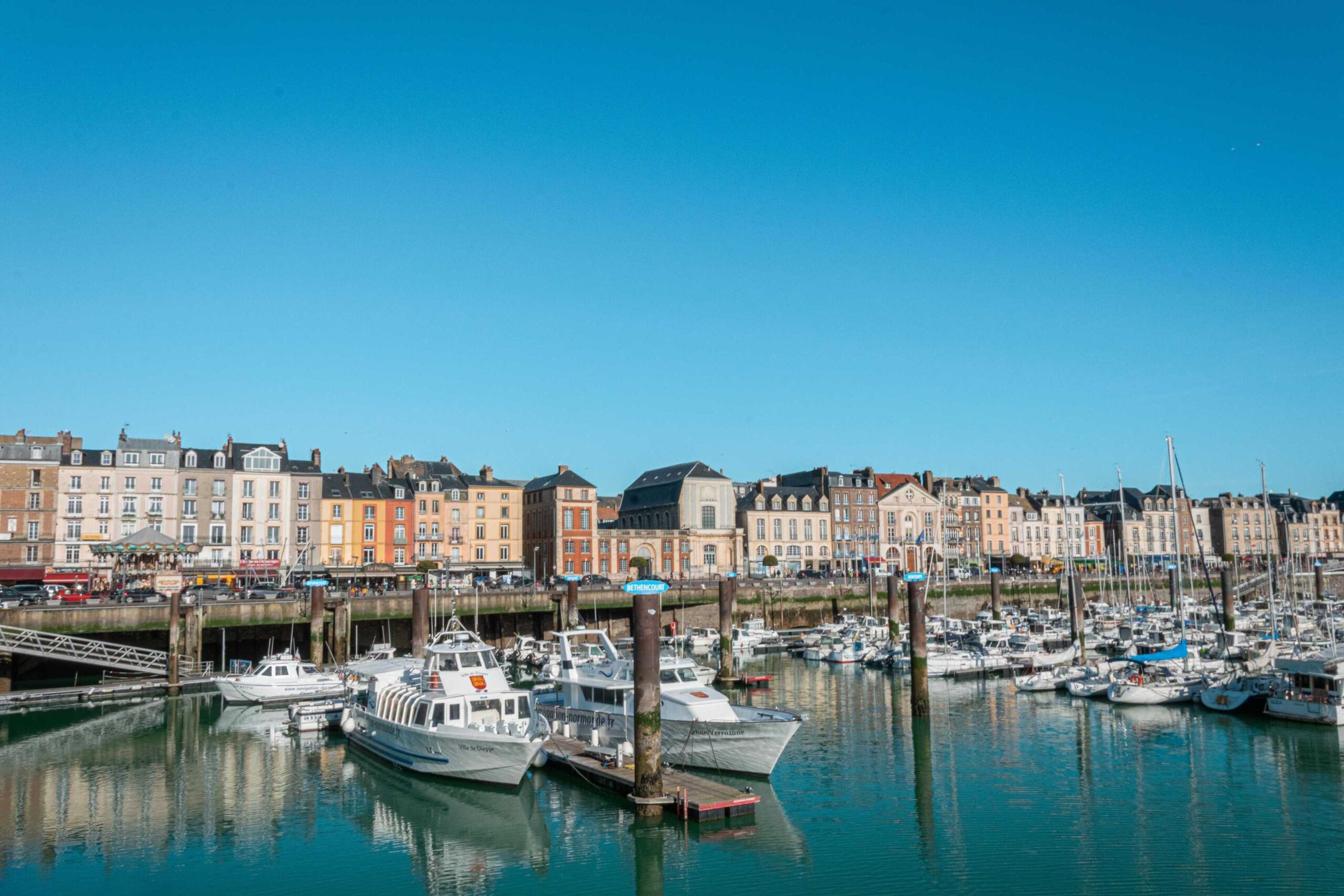 Harbour scene with boats moored under a blue sky in Port of Dieppe in Normandy.
