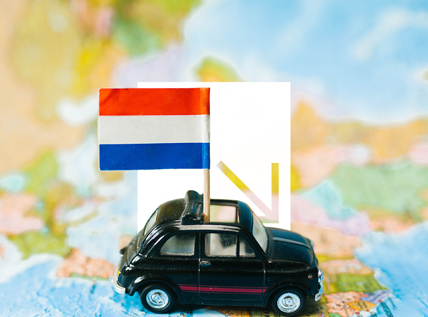 Toy car with the Netherlands flag placed on a map background.