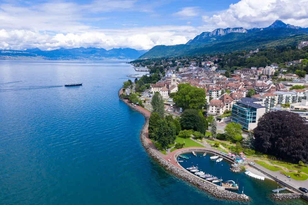 Bird's-eye view of Evian les Bains featuring the cityscape, the lake and the Alps in the background.