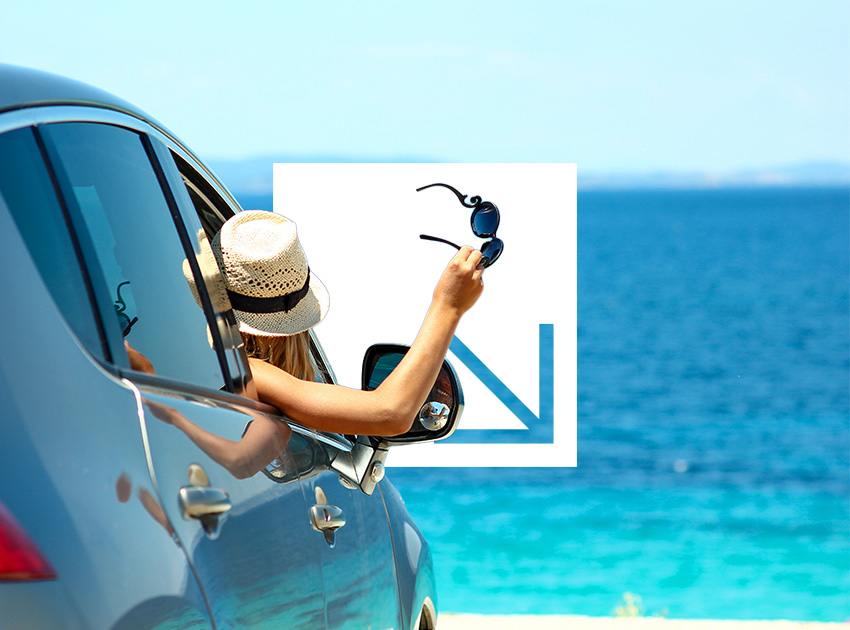 Woman in a car by the ocean holding sunglasses out of the window, representing relaxed travel backed by car hire excess insurance.
