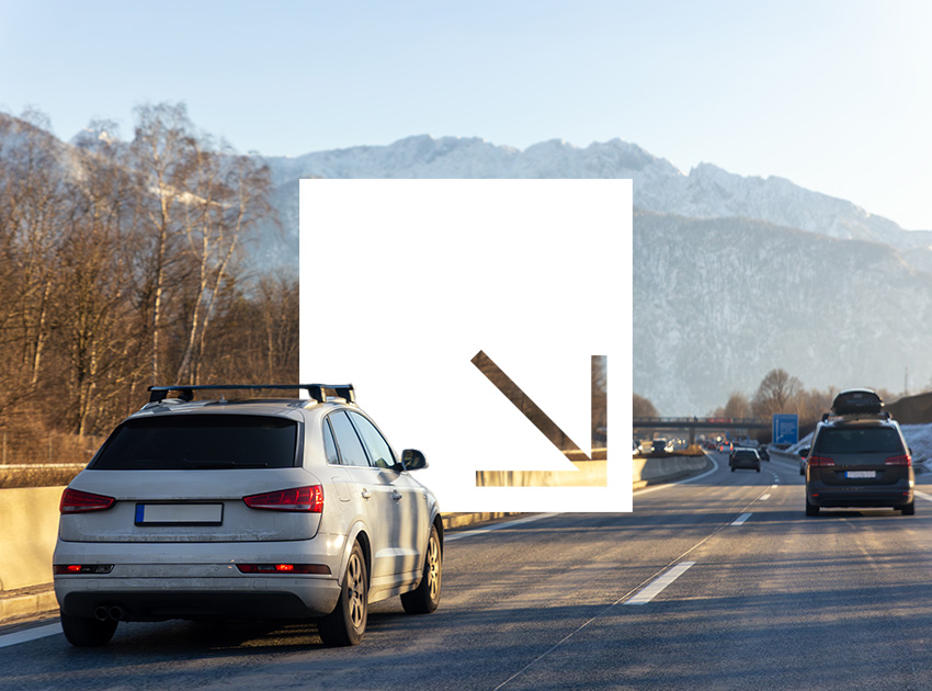 Cars driving on a motorway with snowy mountain peaks in the distance, linking alpine travel with car hire excess insurance protection.