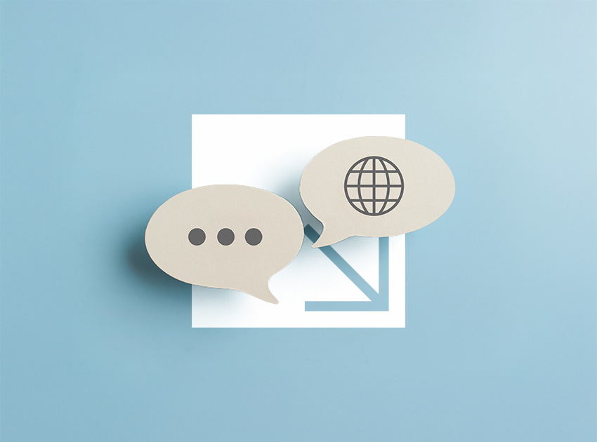 Two speech bubble icons, one with dots and one with a globe, symbolising useful travel phrases for those renting cars abroad with car hire excess insurance.