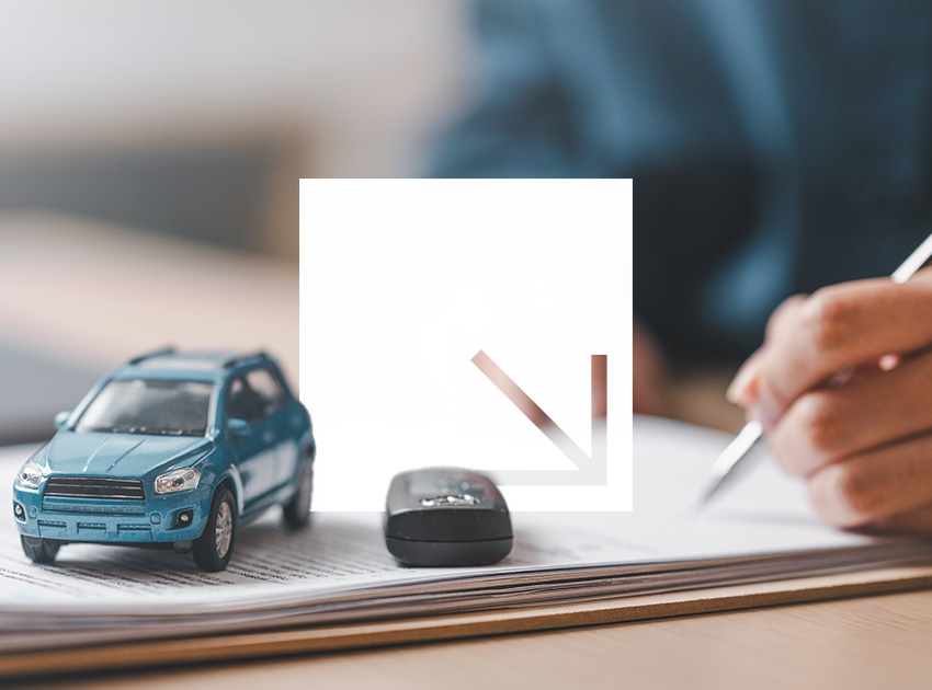 Toy car and car key on top of rental paperwork while someone writes, showing the importance of understanding car hire excess insurance terms.