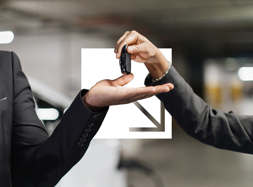 Two people exchanging car keys in a parking garage, highlighting the role of regulators and the importance of car hire excess insurance.