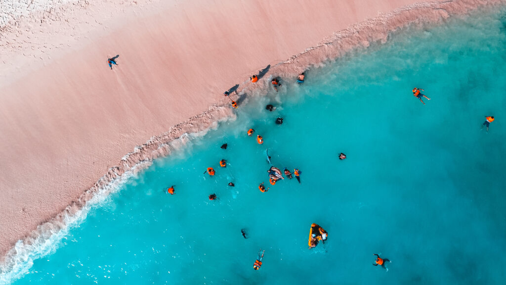 Birds eye view of a beach with golden sand and a deep blue sea
