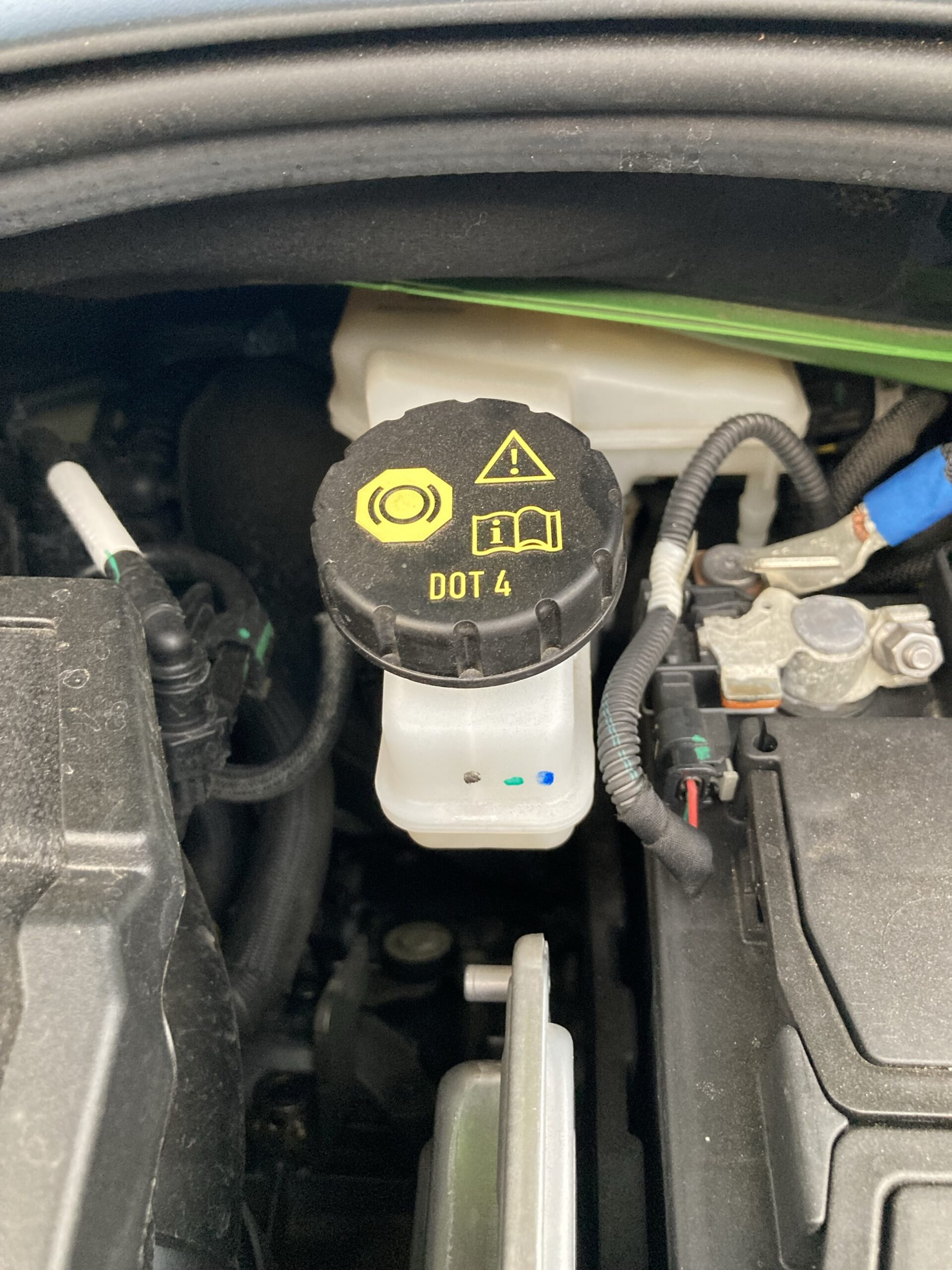 Brake fluid reservoir located underneath car bonnet
