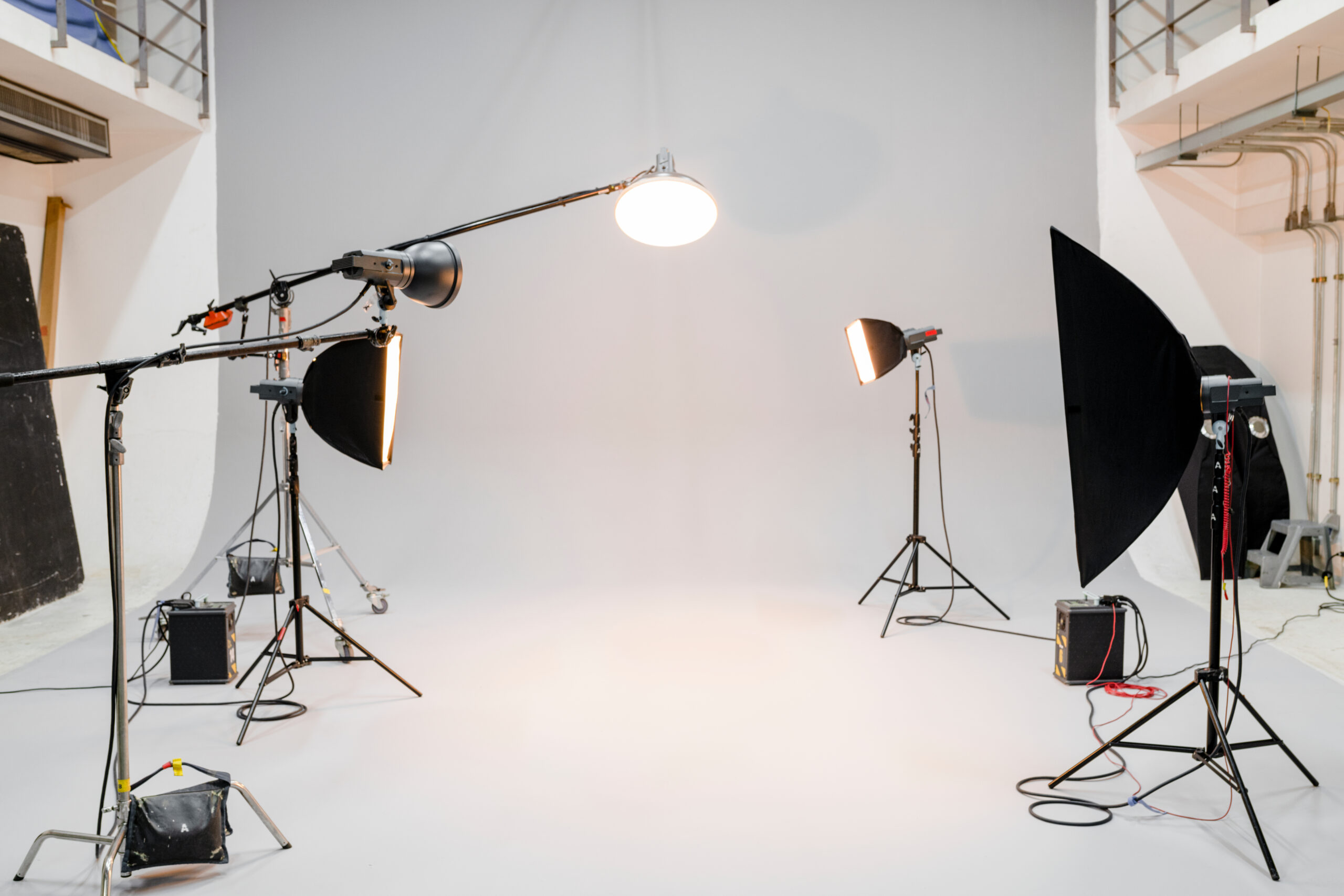 All white photography studio with five lamps all turned on producing a lot of heat