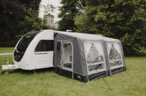 Vango Balletto caravan awning attached to side of touring caravan parked in a green grassy field